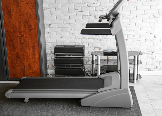 Treadmill in room on brick wall background